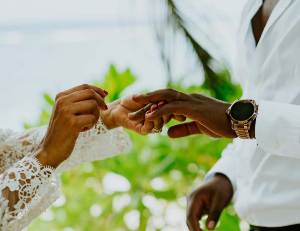 A wedding ceremony on a white sandy beach with the sea in the background.