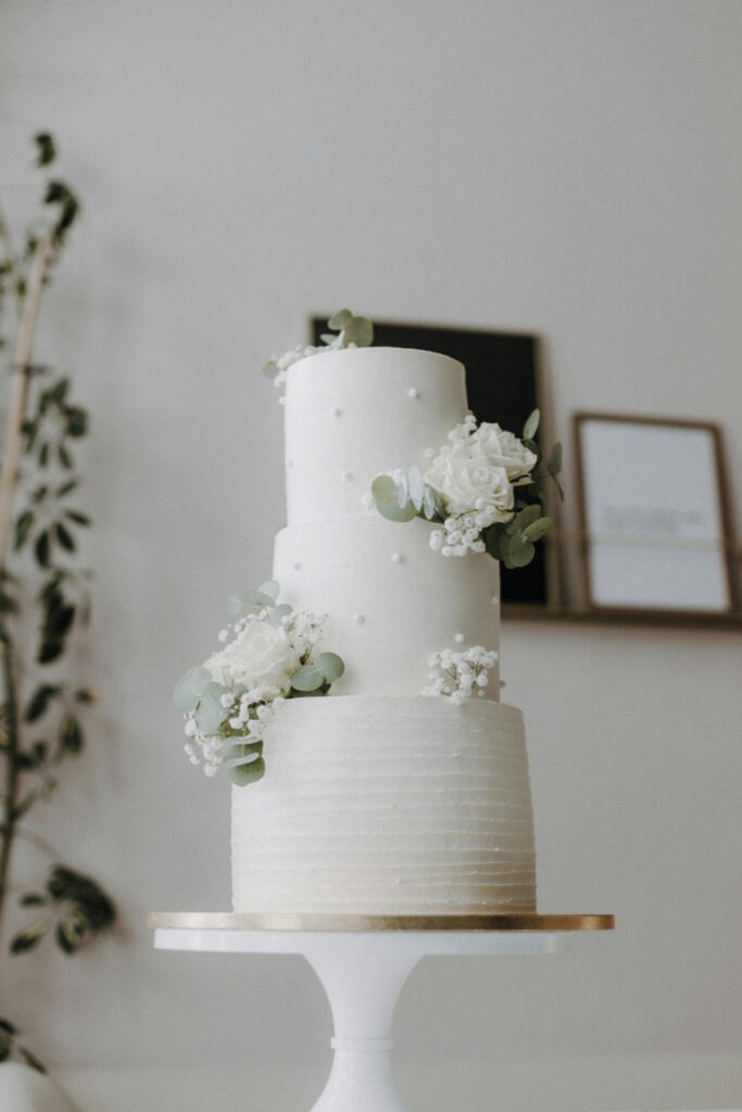 A beautiful white wedding cake decorated with a few flowers. 